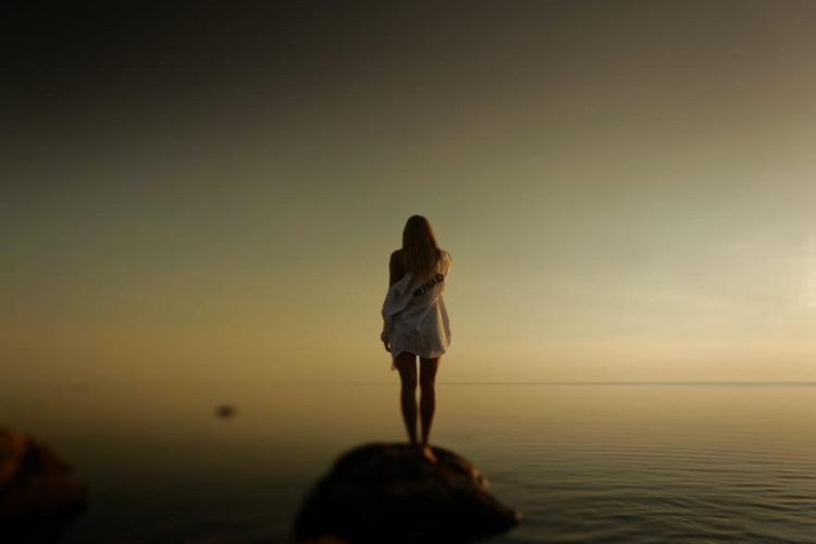 Perfil de chica frente a un mar en calma.